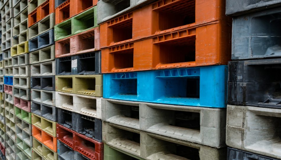 Tall stacks of multi-colored plastic shipping pallets.